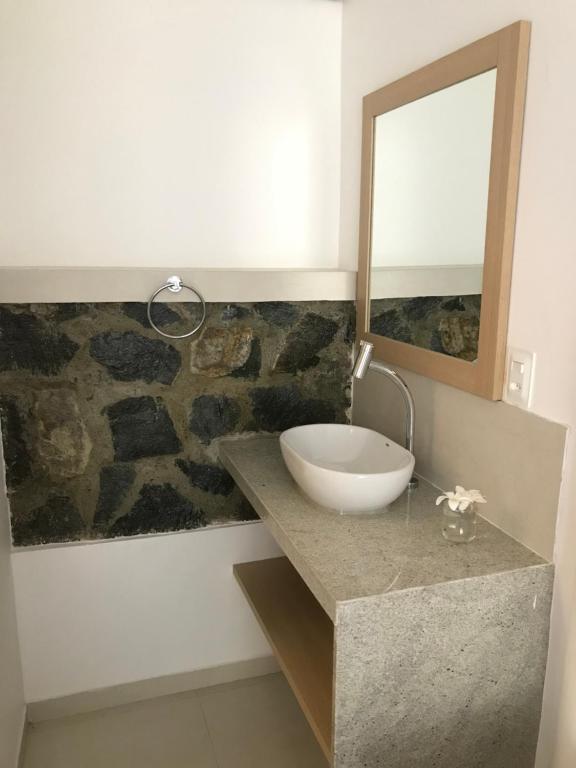 a bathroom with a sink and a mirror on a counter at Suites Amma Noronha in Fernando de Noronha