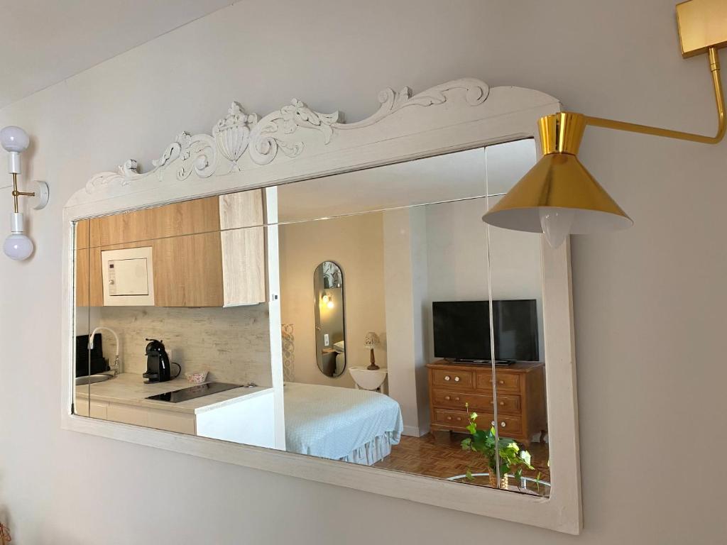 a mirror hanging on a wall in a bedroom at Puerta al cielo Suite in Burgos