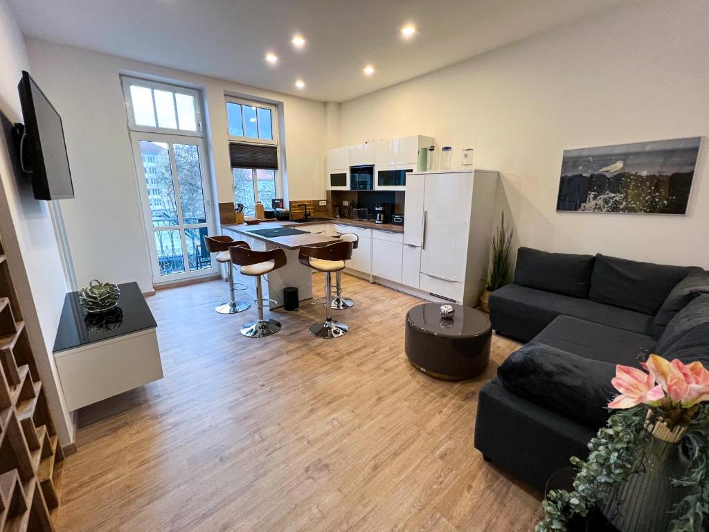 a large living room with a couch and a kitchen at Apartment am Landtag in Erfurt