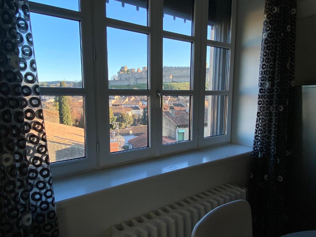 a window with a view of a city from a room at Demeure Saint Louis Historic manor, City 700m, parking,A C,Clim,WIFI, heated pool, city view in Carcassonne