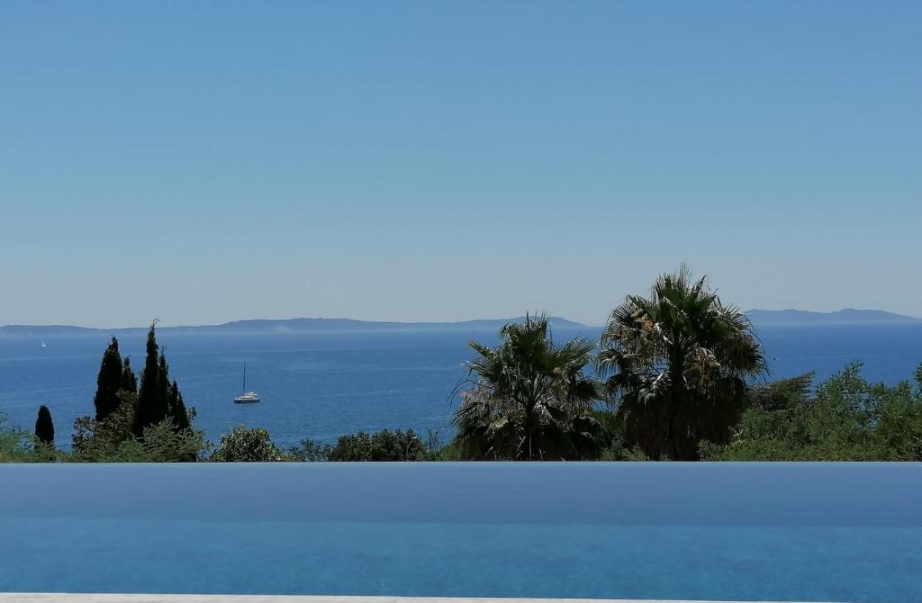 a large swimming pool with a view of the ocean at Villa Gabiano in Rayol-Canadel-sur-Mer