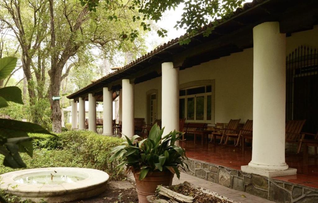 ein Haus mit Veranda und einem Waschbecken im Garten in der Unterkunft Hotel Rancho El Morillo in Saltillo