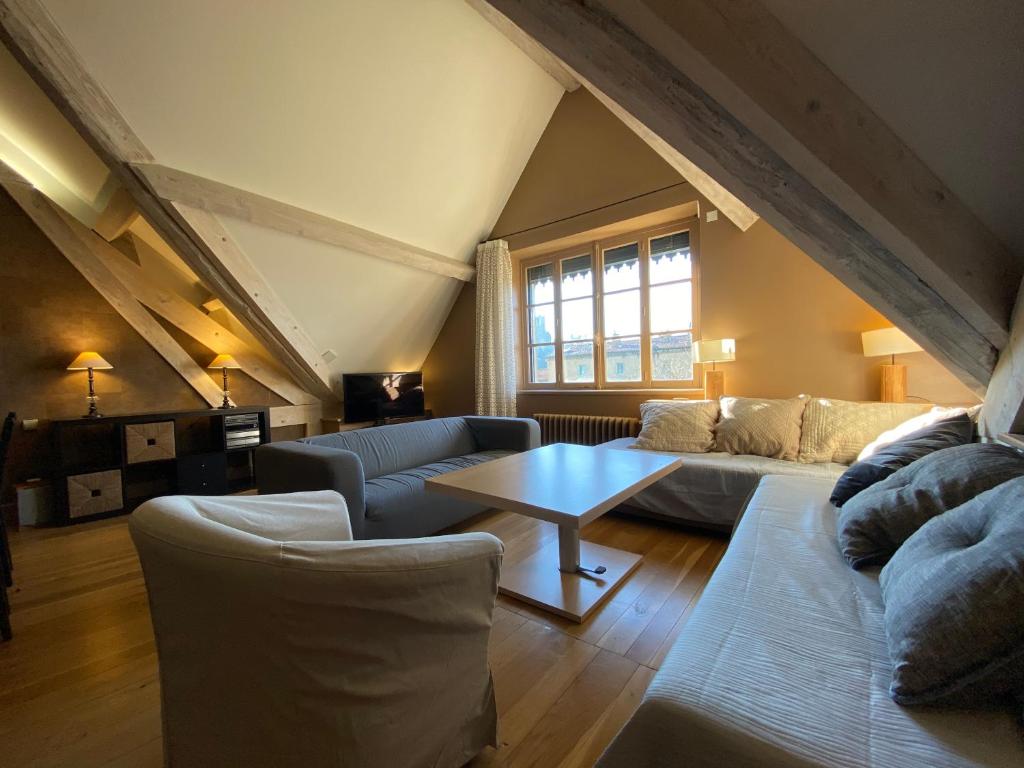 a living room with a couch and a table at Demeure Saint Louis Historic manor, City 700m, parking,A C,Clim,WIFI, heated pool, city view in Carcassonne