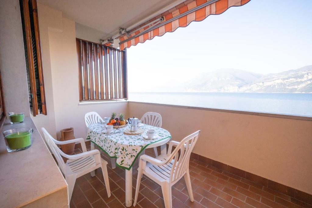 stół i krzesła na balkonie z widokiem na wodę w obiekcie Peler Beth's House w Brenzone sul Garda
