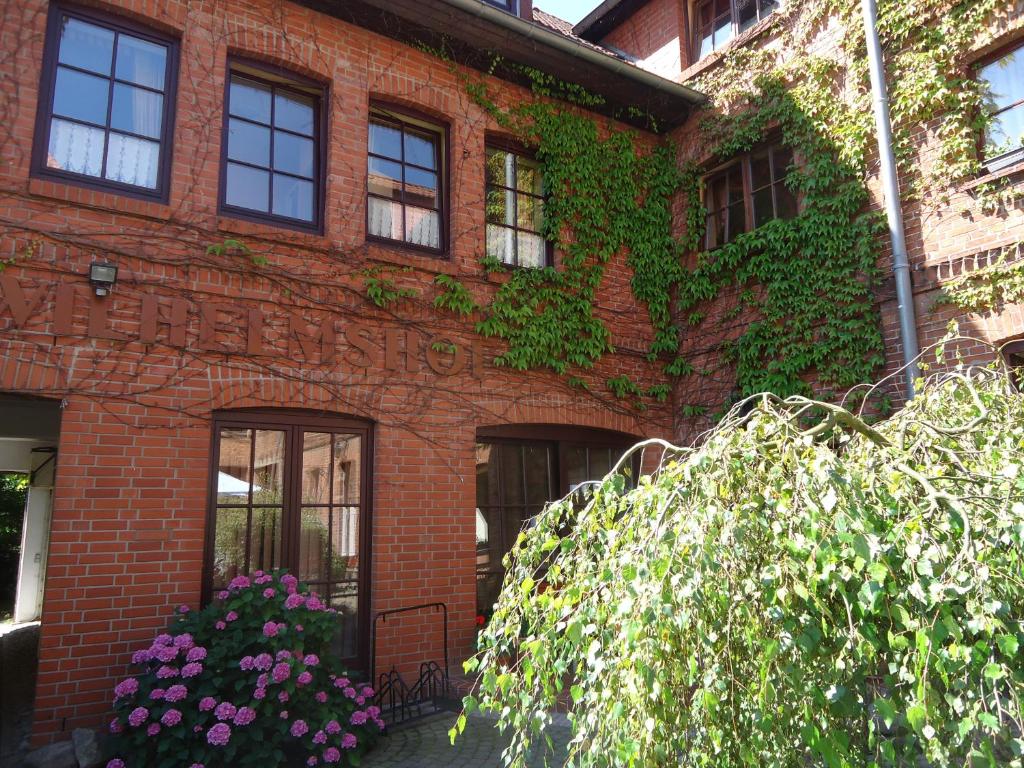 a red brick building with ivy on it at Hotel Wilhelmshof in Ribnitz-Damgarten