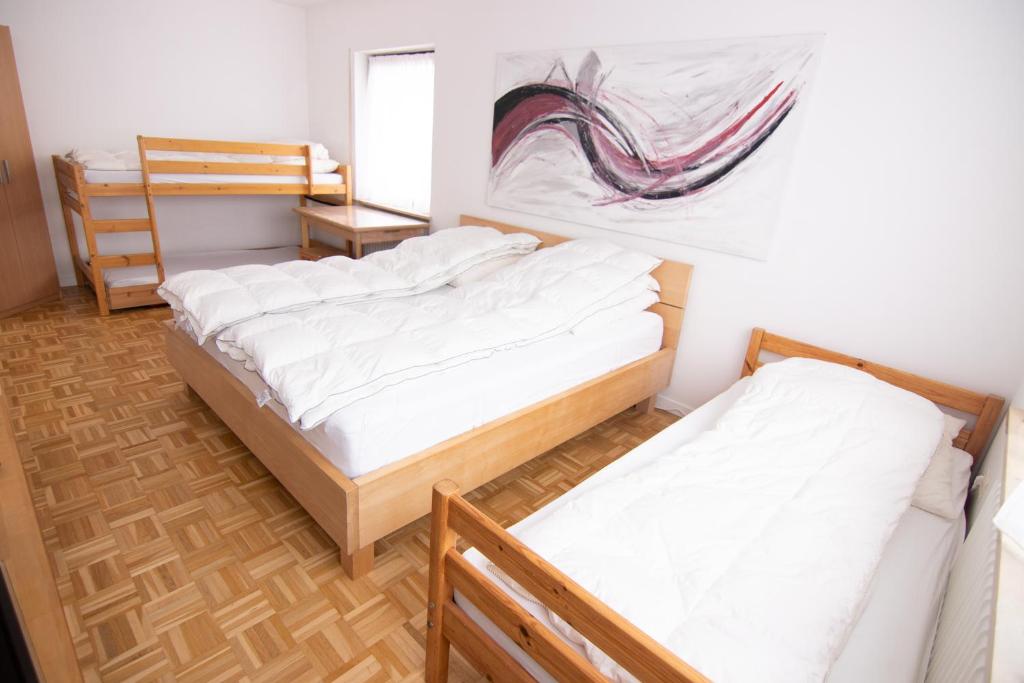 een kamer met 2 bedden en een schilderij aan de muur bij Familienzimmer in Neumarkt in der Oberpfalz