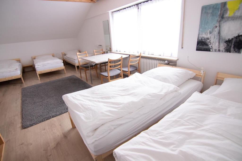 a room with two beds and a table and chairs at Schönes Familienzimmer in Neumarkt in der Oberpfalz