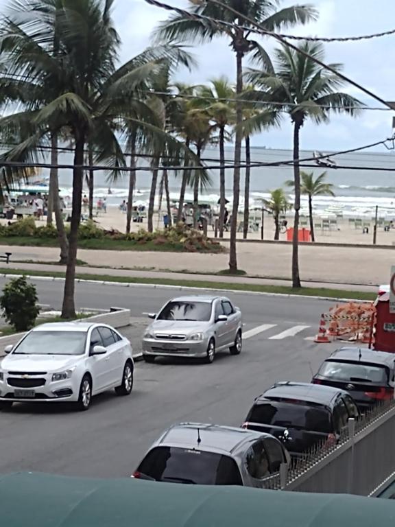 a group of cars parked on a street near the beach at Sol e mar 2 in Praia Grande
