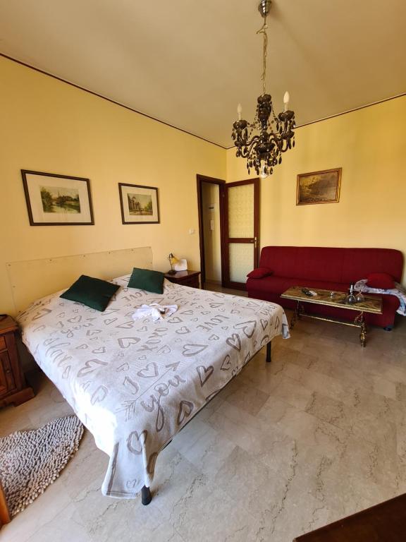 sypialnia z dużym łóżkiem i czerwoną kanapą w obiekcie Casa dell amore 3 w San Remo