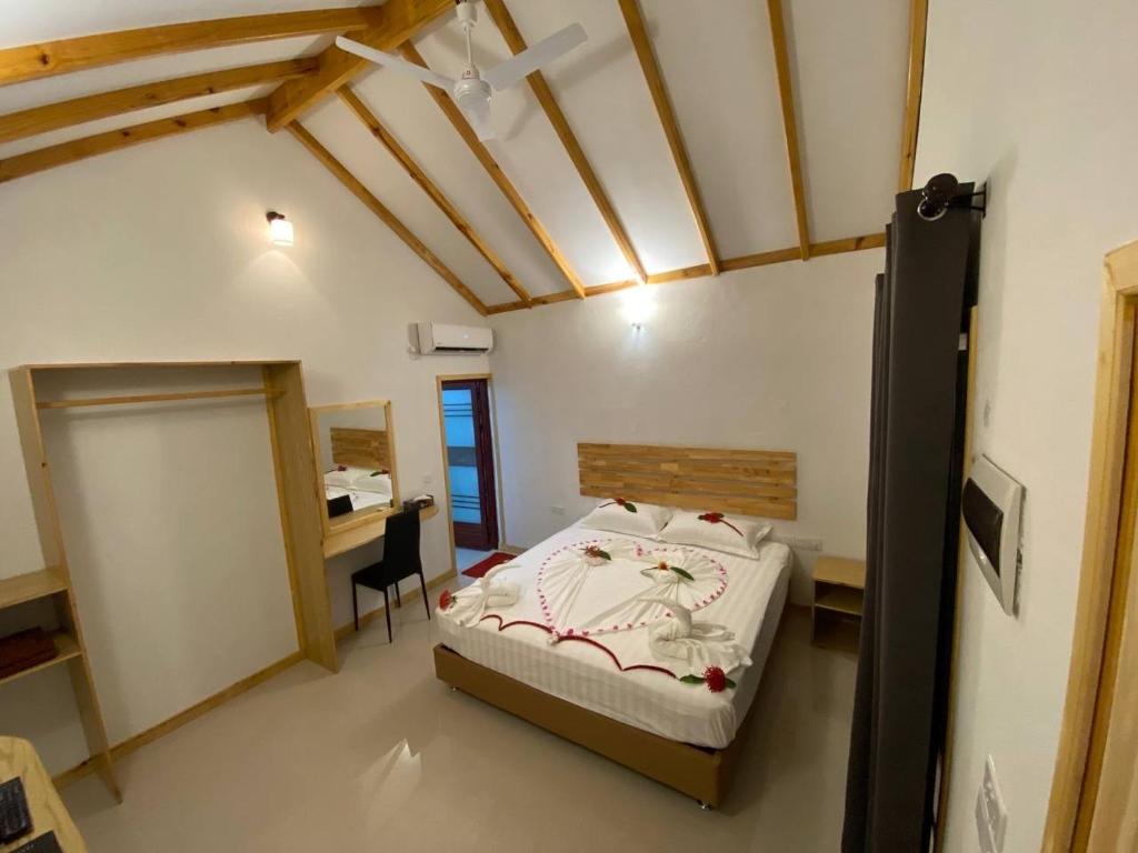 a bedroom with a bed and a desk in a room at Thoddoo Haisha inn, Maldives in Thoddoo