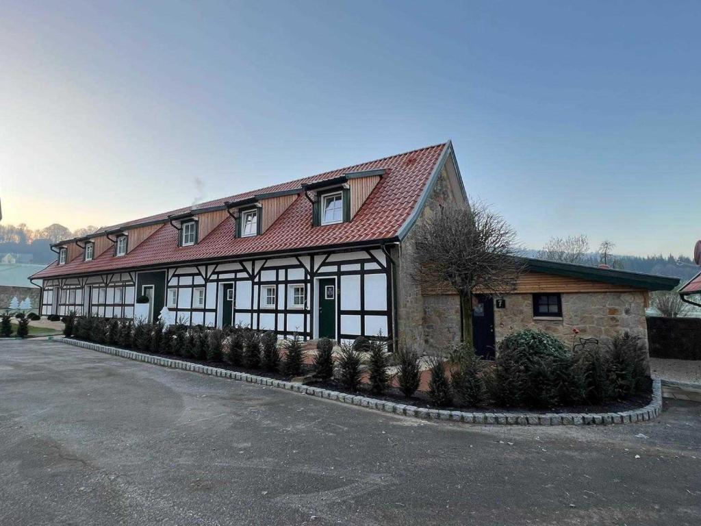 budynek z czerwonym dachem i roślinami w obiekcie DRIEHOF LifeStyle Classic Apt 2 w mieście Tecklenburg