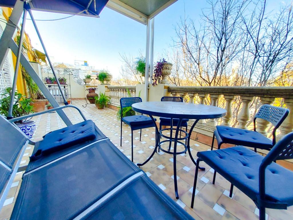 a patio with a table and chairs on a balcony at ATICO DUPLEX ALAMEDA de HERCULES GRAN TERRAZA in Seville