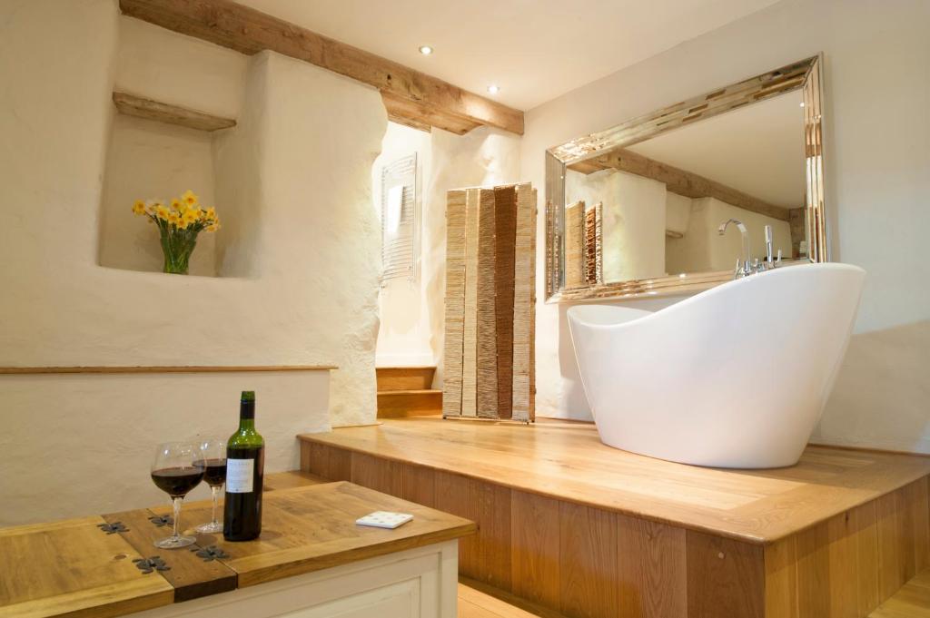 a bathroom with a white tub and a bottle of wine at Trefloyne Manor in Tenby