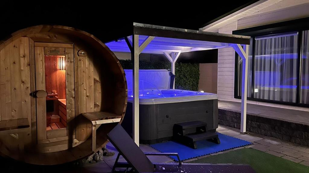 eine Whirlpool-Badewanne im Hinterhof in der Nacht in der Unterkunft Chalet Buutengeweun, met luxe JACUZZI en TONSAUNA in Sint-Annaland