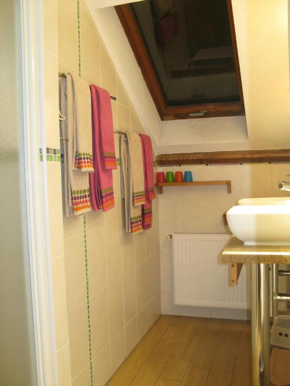 a bathroom with a sink and towels on the wall at Les Chambres de l&#39;Ile in Metz