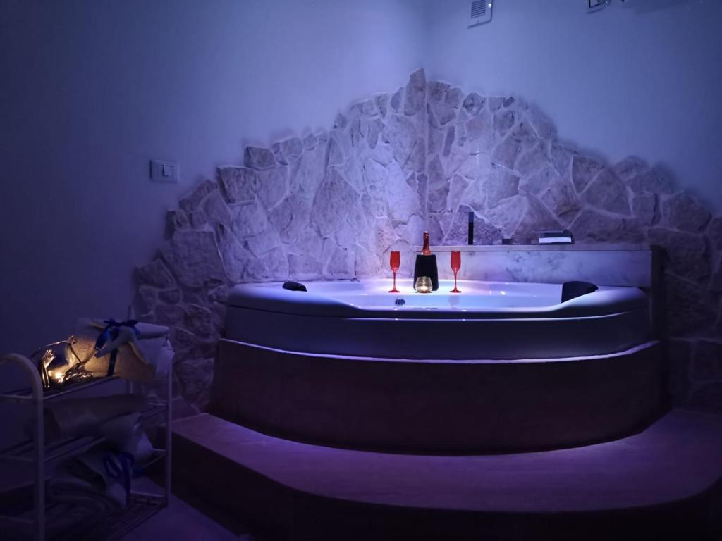 a bath tub in a room with a stone wall at Villa Rhaele in Taranto