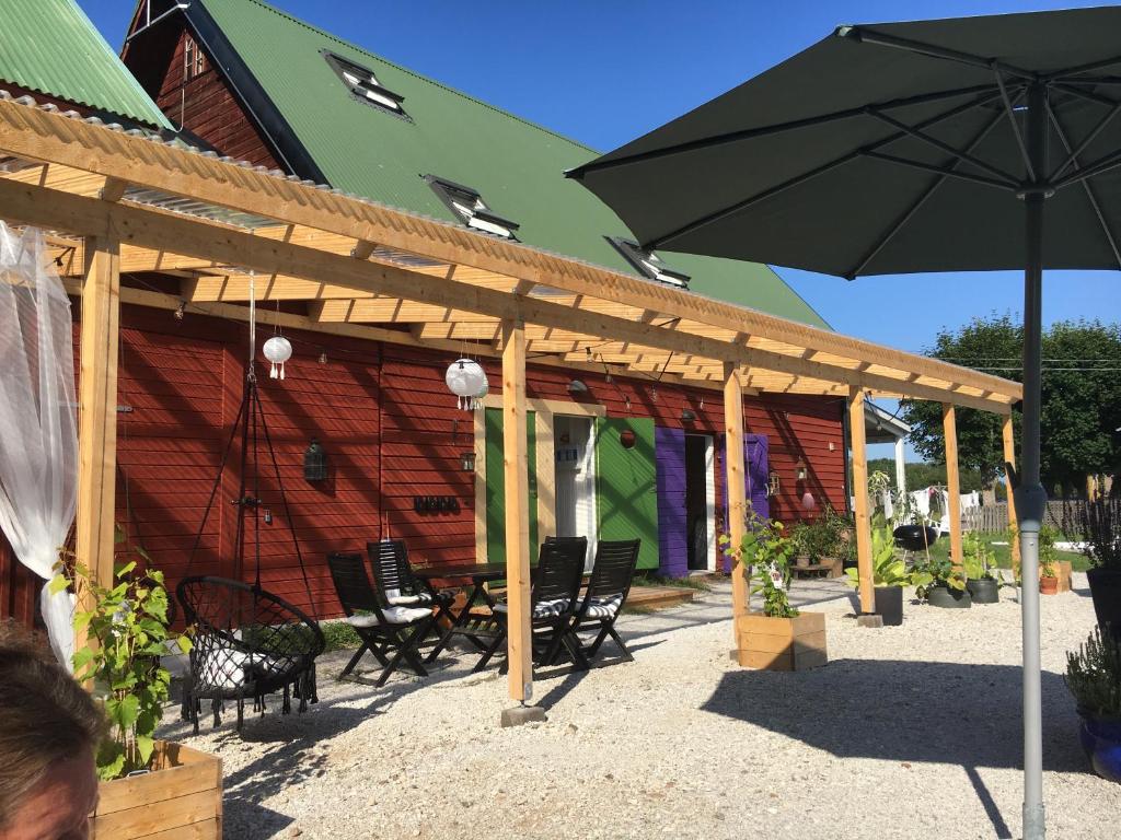 a wooden patio with chairs and an umbrella at Galleriet BnB in Stenkyrka