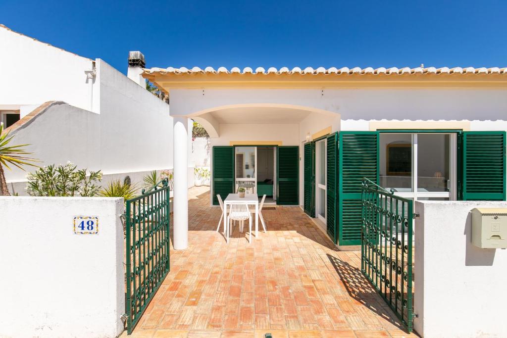 Casa con persianas verdes y patio en Cozy and sunny villa just some steps from the sea, en Luz