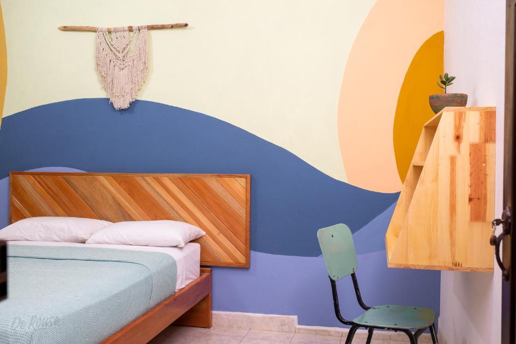 Caracolí的住宿－Amagua Hostel，一间卧室配有一张床和一把椅子