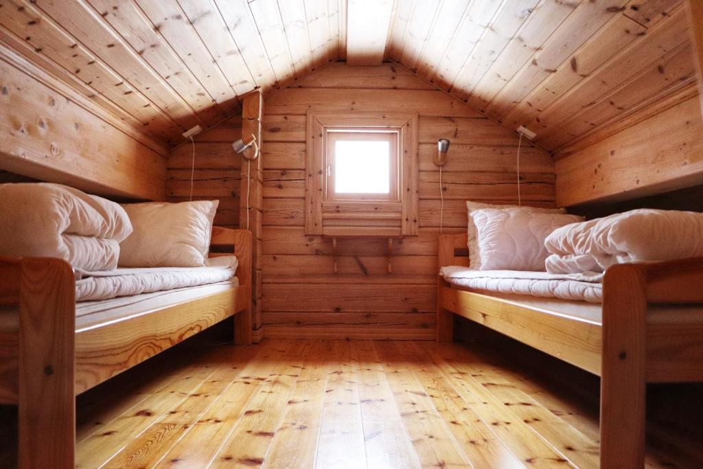 Habitación con 2 camas en una cabaña de madera en Noretjärns Stugby, en Årjäng