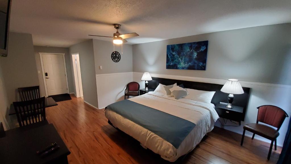 a hotel room with a large bed and two chairs at Celadon Lodge in Radium Hot Springs