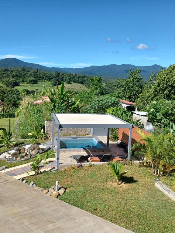 un padiglione con piscina in giardino di Les Balcons du Parc a Petit-Bourg