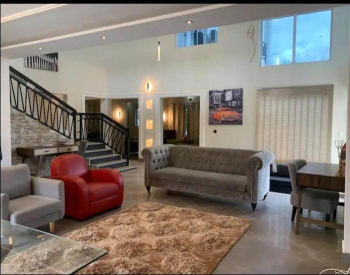 sala de estar con sofá y silla roja en AlanVal Suites en Accra