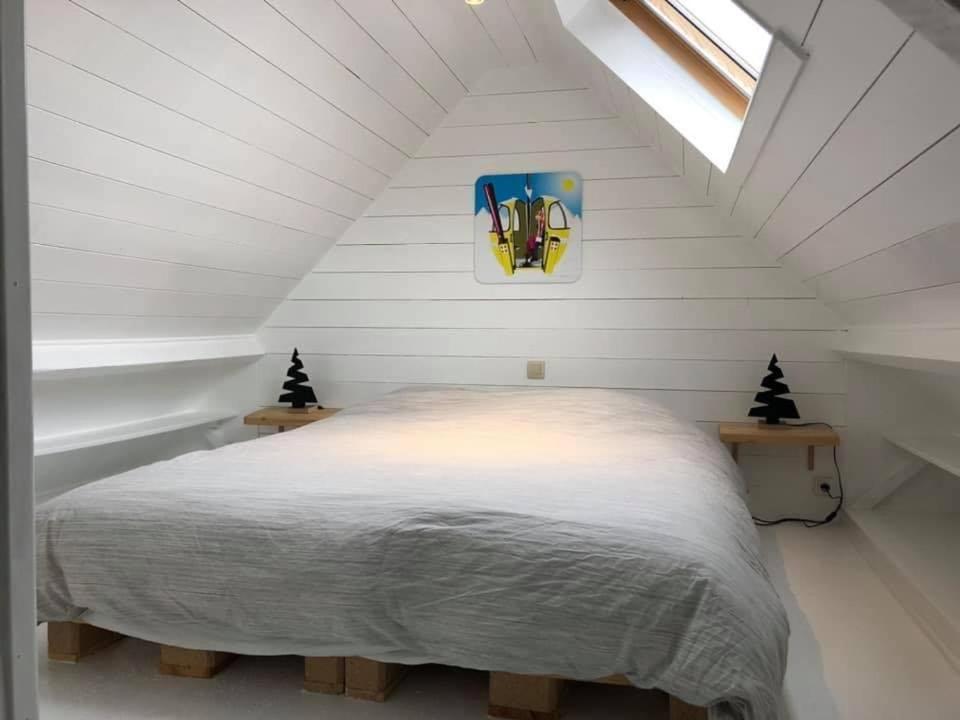 1 dormitorio con 1 cama blanca en el ático en Le mazot d’Edouard et Celestin, en Profondeville