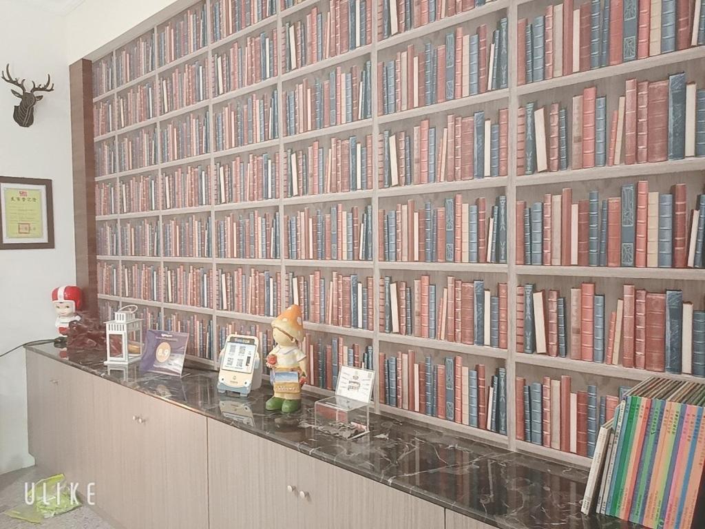 a large library with a large wall of books at Happy Life B&amp;B in Donggang