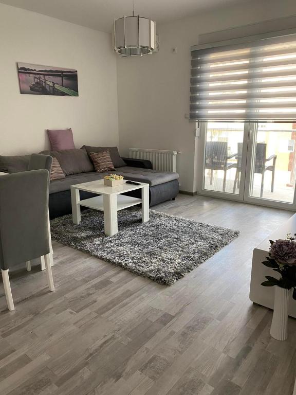 ein Wohnzimmer mit einem Sofa und einem Tisch in der Unterkunft Apartmani Milić Banja Koviljača in Banja Koviljača