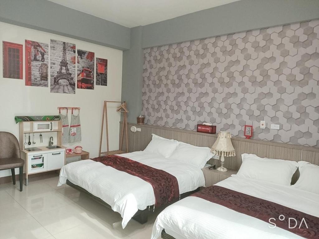 a bedroom with two beds and a wall with posters at Happy Life B&B in Donggang