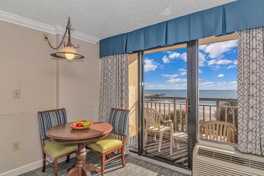 a dining room with a table and chairs and a balcony at Holiday Pavilion 405 in Myrtle Beach