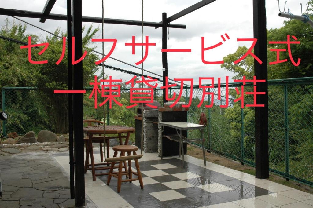 ein Schild für eine Terrasse mit Stühlen und einem Kamin in der Unterkunft 熱海貸切り別荘網代の家 in Ajiro