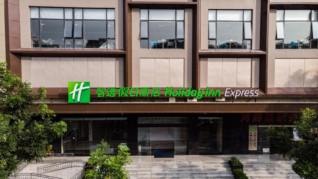 um edifício com uma placa na frente dele em Holiday Inn Express Shantou City Center, an IHG Hotel em Shantou