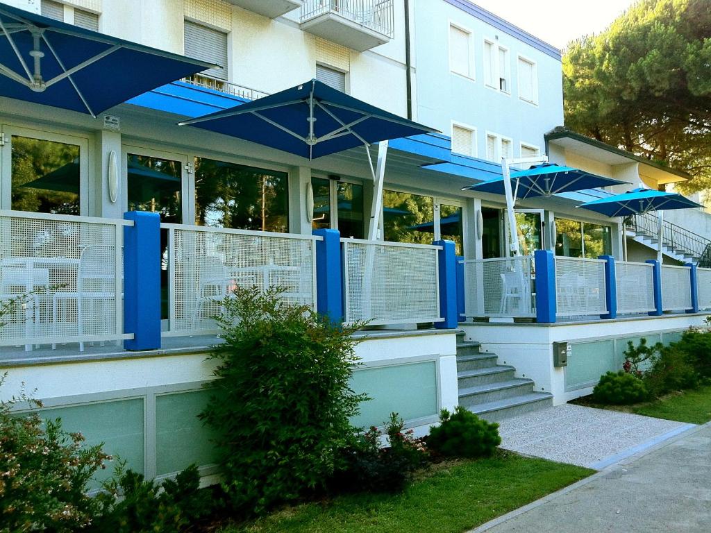 un edificio con sombrillas azules a un lado. en Hotel Bermuda, en Marina di Ravenna