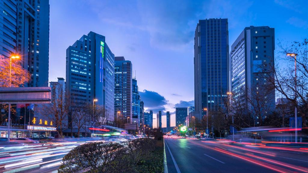 una calle de la ciudad con edificios altos por la noche en Holiday Inn Express Qingdao City Center, an IHG Hotel, en Qingdao