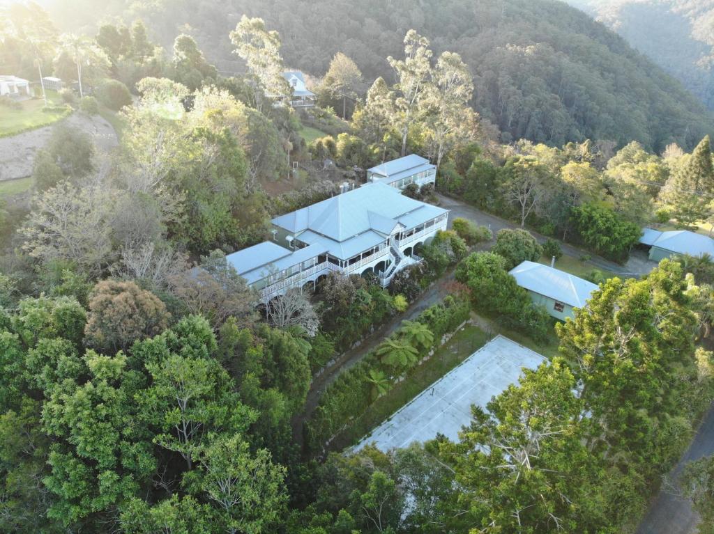 Mount Glorious的住宿－Maiala Park Lodge，树林中房屋的空中景观