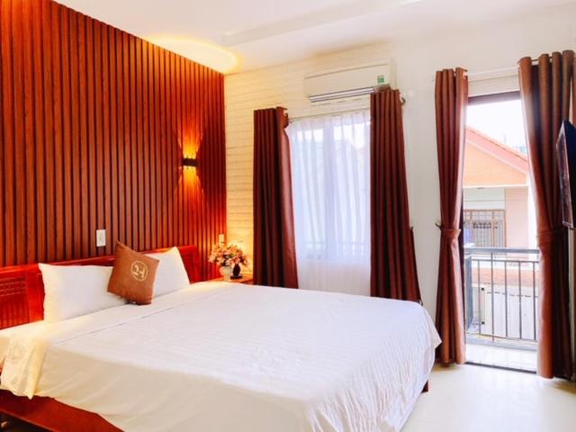 a bedroom with a large white bed and a window at Poetic Hue Hotel & Spa in Hue