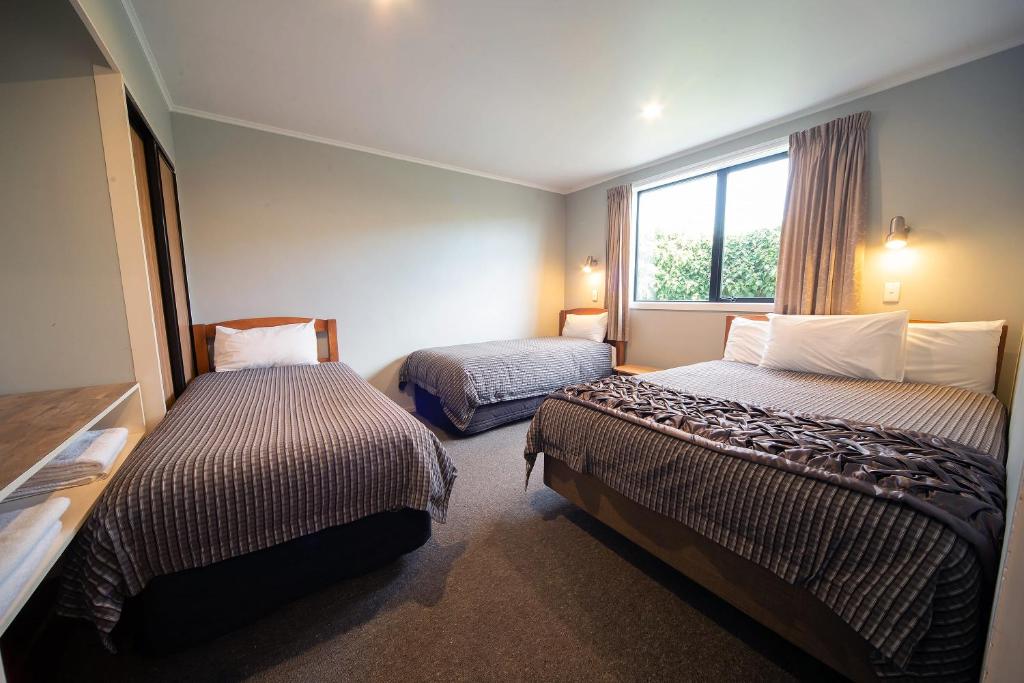 a hotel room with two beds and a window at Coronation Park Holiday Park in Ashburton