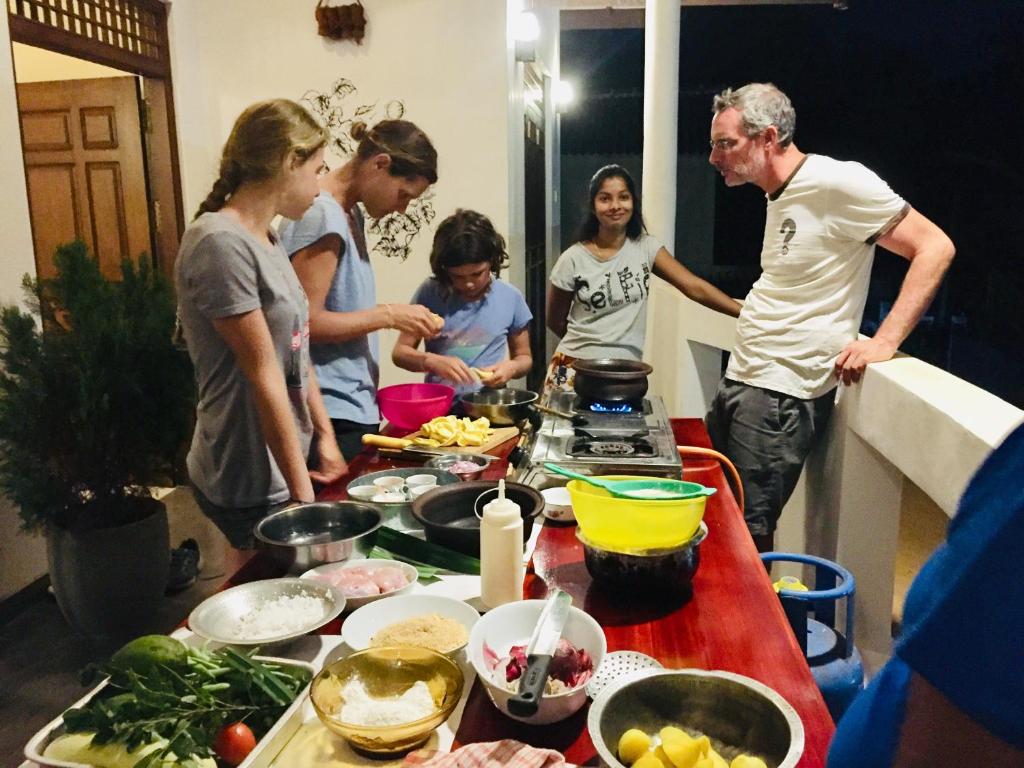 阿努拉德普勒的住宿－Sweet Home Tourist Rest, Cooking Classes & Tours，一群站在厨房准备食物的人