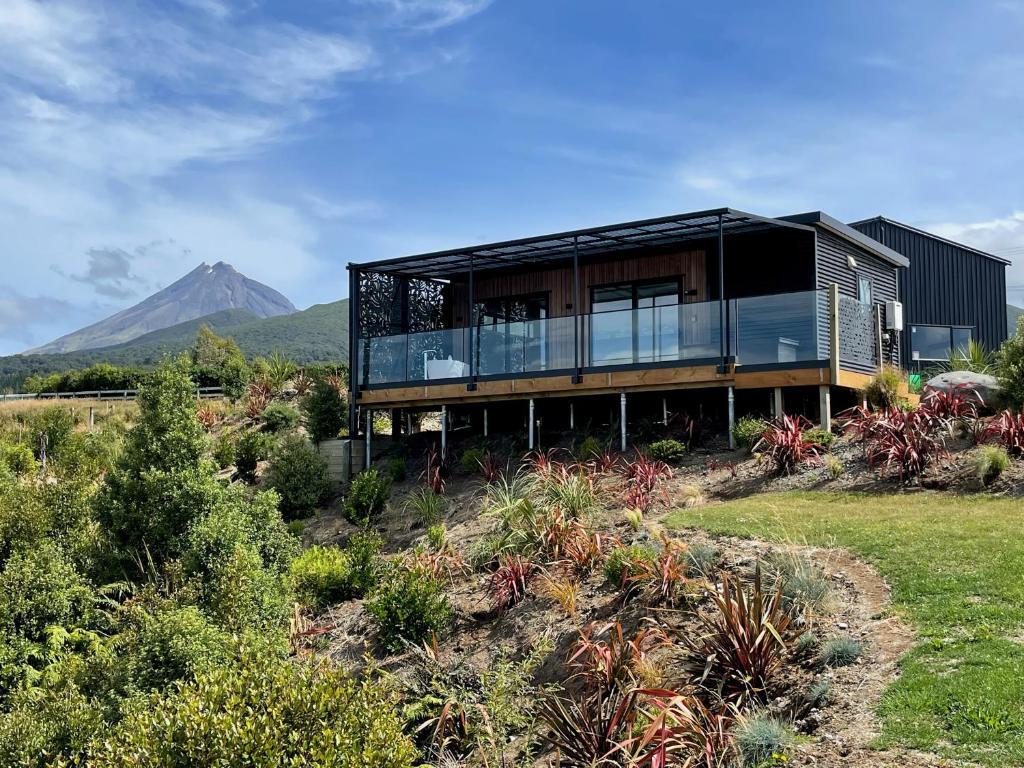 a house on a hill with a mountain in the background at Mangorei Heights - New Plymouth in New Plymouth