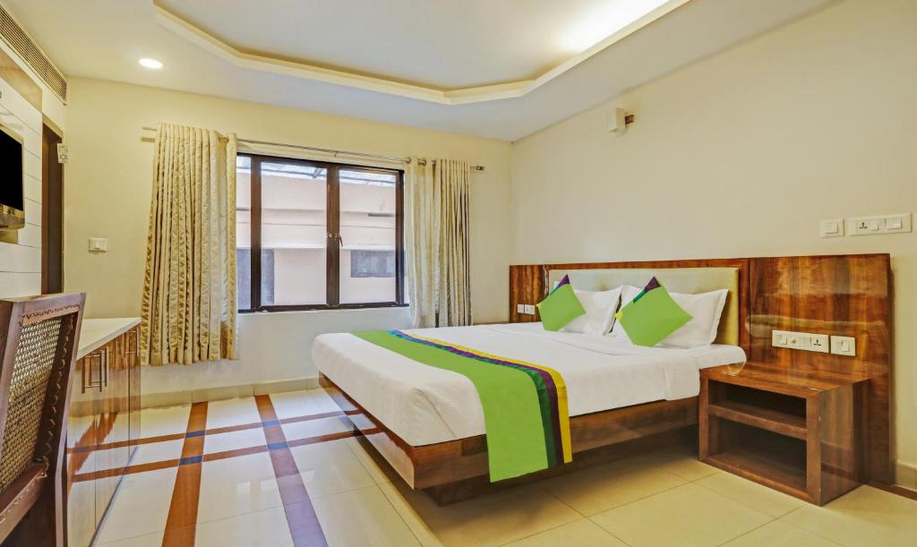 1 dormitorio con cama y ventana en Treebo Trend Time Square Marine Drive, en Kochi