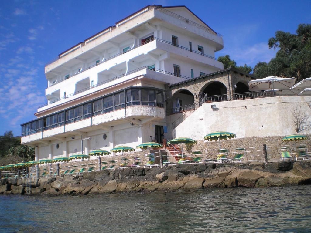 un edificio con sombrillas frente al agua en Hotel Sirena, en Castellabate
