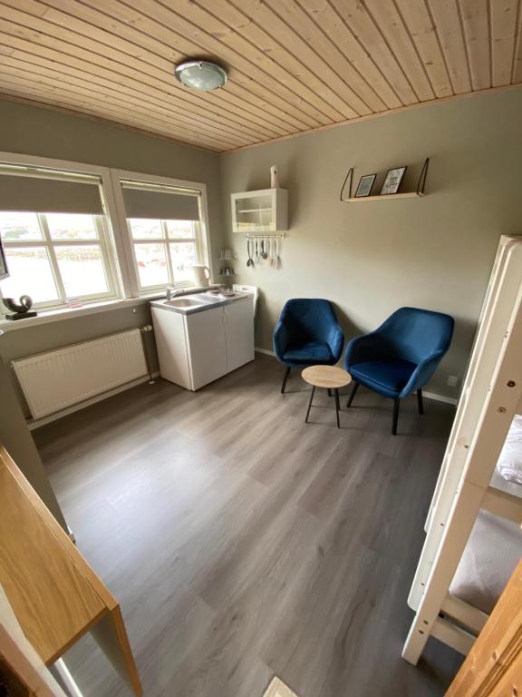 a room with two chairs and a table and a sink at Kristjanshavn in Miðvágur