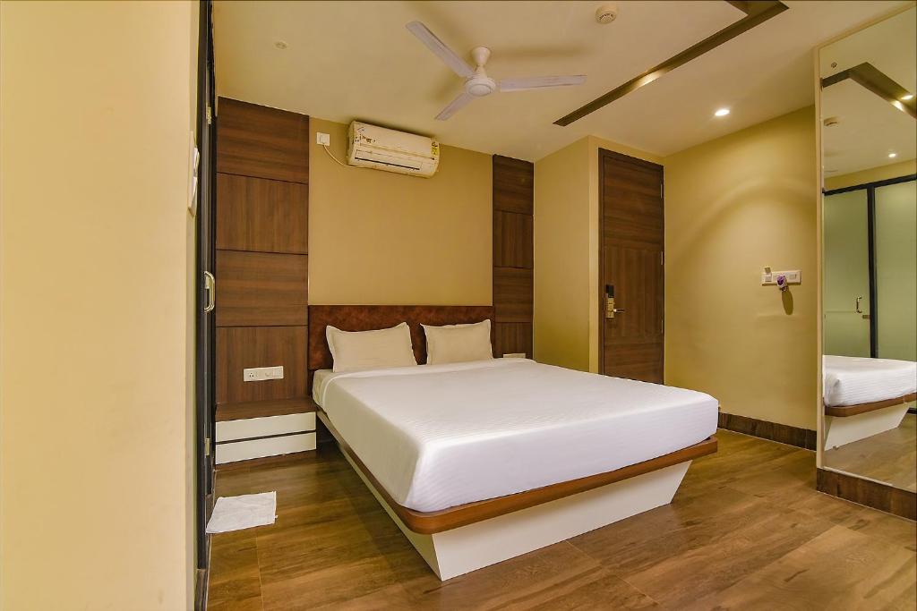a bedroom with a white bed and a mirror at FabHotel Eros 282 in Kolkata