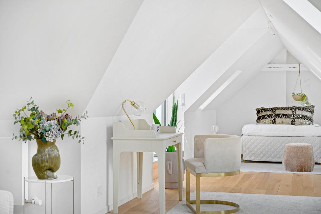 ein weißes Zimmer mit einem Bett, einem Tisch und einem Stuhl in der Unterkunft Sanders Regent - Adorable One-Bedroom Apartment Near Central Square in Kopenhagen