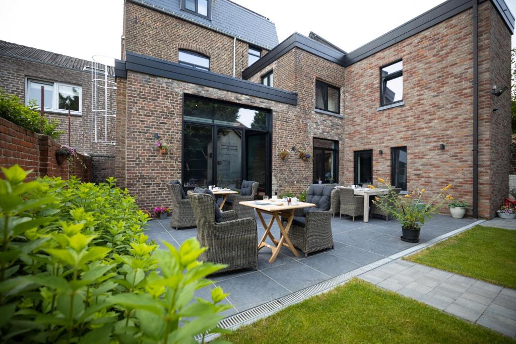 een patio met een tafel en stoelen op een binnenplaats bij B&B Gaudium XII in Tongeren