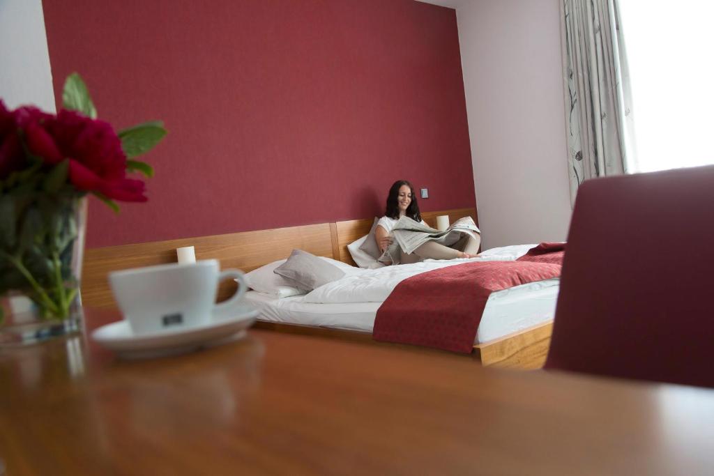 kobieta siedząca na łóżku w pokoju w obiekcie Hotel Greive w mieście Haren