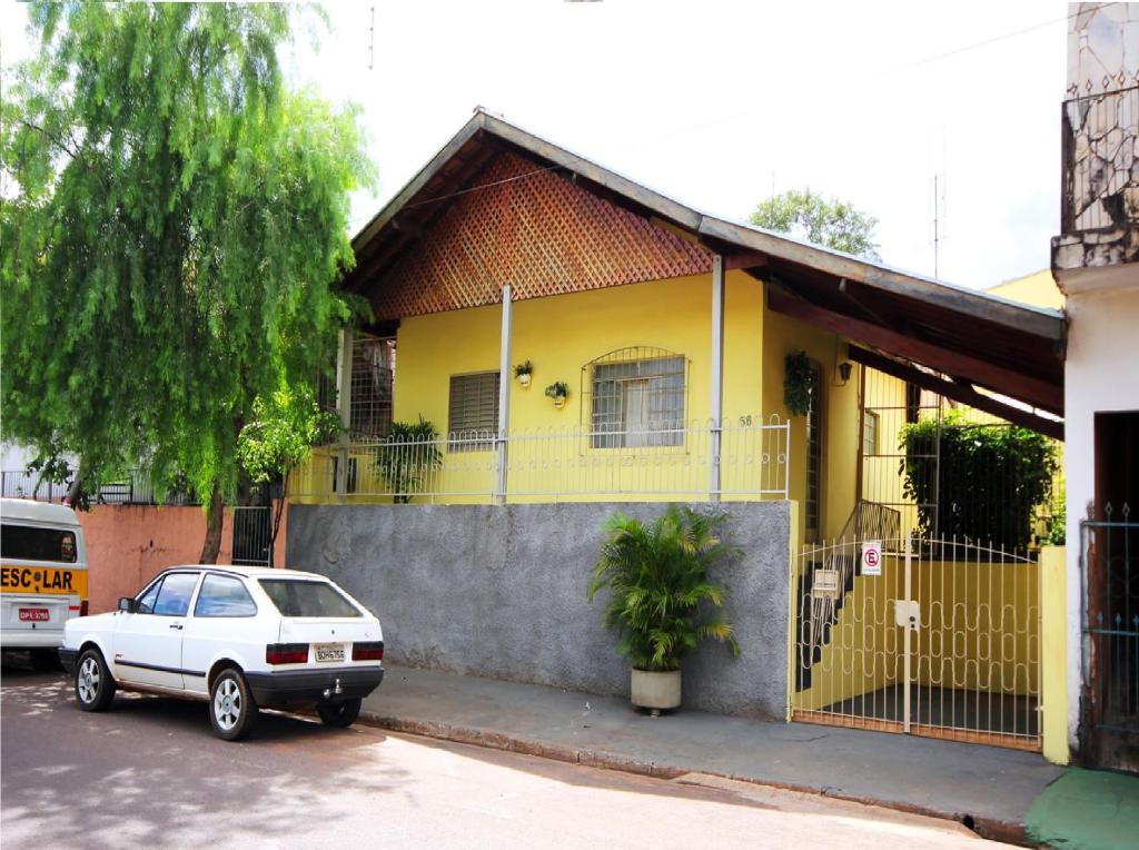 una casa amarilla con un coche aparcado delante de ella en Casa Pagotto, en Olímpia