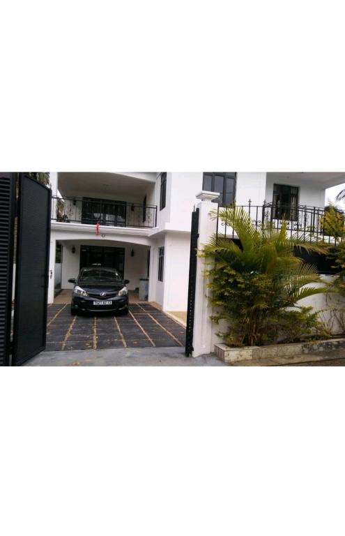 un coche aparcado en un aparcamiento frente a un edificio en Sunrise Sensation holiday home. en Centre de Flacq